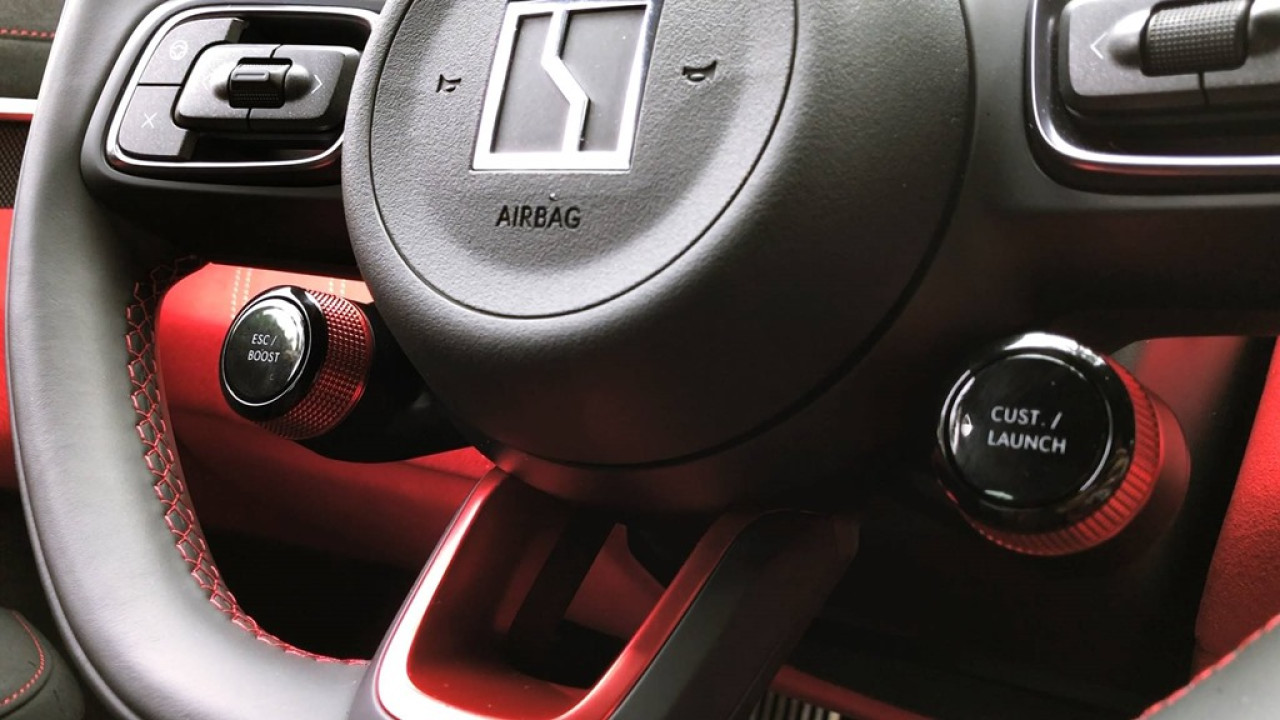 軚盤上左右兩個旋鈕，提供不同嘅性能駕駛模式。